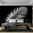 Black and white feather wallpaper creates dramatic contrast in a minimal living room setting