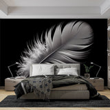 Black and white feather wallpaper creates dramatic contrast in a minimal living room setting
