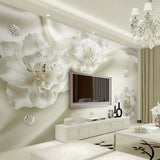 White 3D floral wallpaper creating depth in a modern living room with natural light highlighting the textured blooms