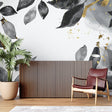 Black and gold leaf wallpaper in modern living room creating elegant atmosphere
