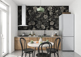 Black and grey floral wallpaper creating drama in a modern living room with grey sofa and metallic accents