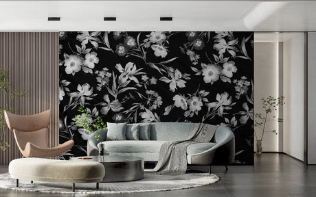 Black and white floral wallpaper adding drama to a modern living room with grey sofa and natural light