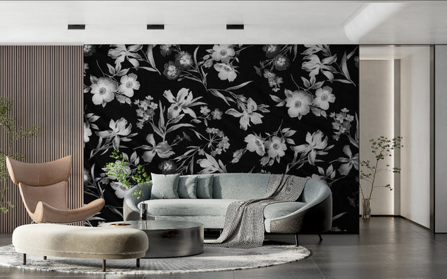 Black and white floral wallpaper adding drama to a modern living room with grey sofa and natural light