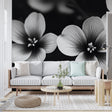 Black and white floral wallpaper mural creating dramatic contrast in a modern living room with minimalist furniture