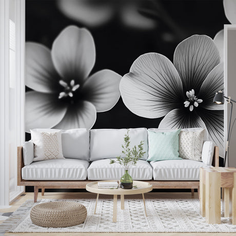 Black and white floral wallpaper mural creating dramatic contrast in a modern living room with minimalist furniture