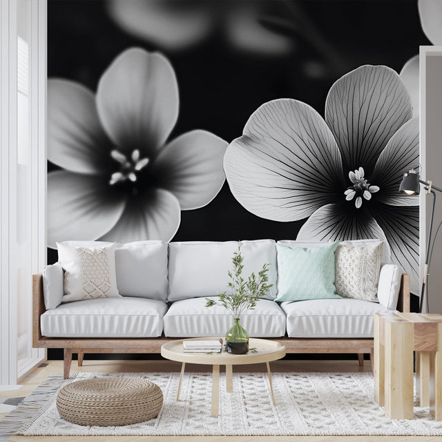 Black and white floral wallpaper mural creating dramatic contrast in a modern living room with minimalist furniture