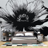 Black and white floral wallpaper creating dramatic contrast in a modern living room with minimal furniture