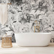 Black and white peony wallpaper mural in modern living room, creating dramatic contrast against neutral furniture
