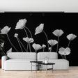 Black and white poppy wallpaper mural creating dramatic impact in a modern living room with minimal furniture