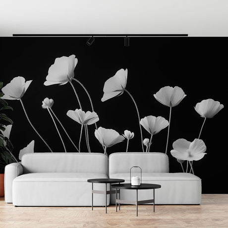 Black and white poppy wallpaper mural creating dramatic impact in a modern living room with minimal furniture