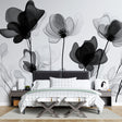 Black and white floral wallpaper mural creating drama in a modern living room with high ceilings and minimal furniture