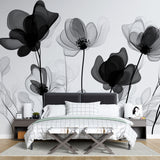 Black and white floral wallpaper mural creating drama in a modern living room with high ceilings and minimal furniture
