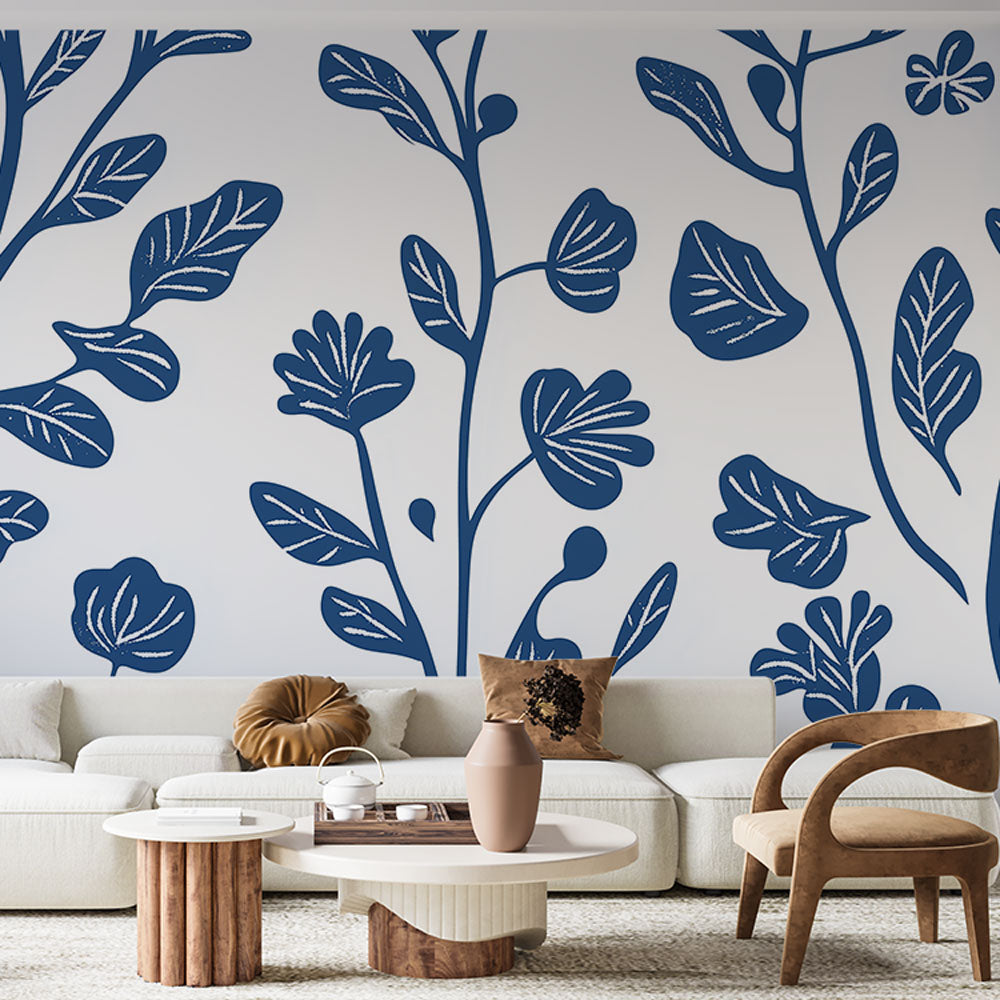 Blue and orange botanical wallpaper mural shown in a bright modern living room, creating a fresh and lively atmosphere