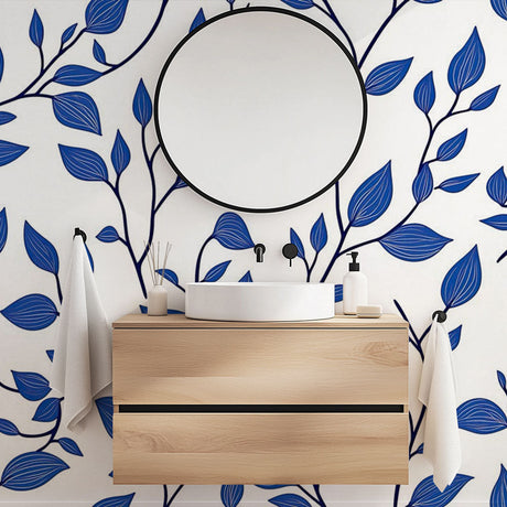 Blue botanical wallpaper mural styled in a bright modern living room with white furniture and natural light