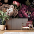 Dark burgundy peony wallpaper in modern living room with gray sofa and golden accents