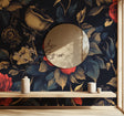Dark floral wallpaper with gold accents creating drama in a modern dining room