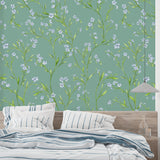 Sage green and blue floral wall mural in a cozy bedroom setting