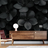 Black floral wallpaper creating dramatic impact in a modern living room with minimalist furniture and natural lighting