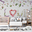 Pink roses Love Letters floral wallpaper in a bright nursery with white furniture
