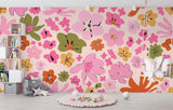 Pink and orange floral wallpaper mural in a bright modern living room, creating a cheerful accent wall
