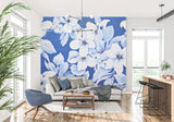 Large white floral wallpaper creating a stunning focal point in a modern living room with blue accents