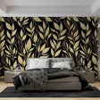 Black and gold leaf wallpaper creating dramatic impact in a modern dining room with ambient lighting