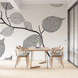 Black and white dotted leaf wallpaper in a bright modern home office, showing how the pattern creates depth and interest