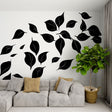 Black and white leaf mural wallpaper in a modern living room creating dramatic contrast against furniture