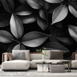 Black and white leaf pattern mural wallpaper creating drama in a modern living room with minimal furniture