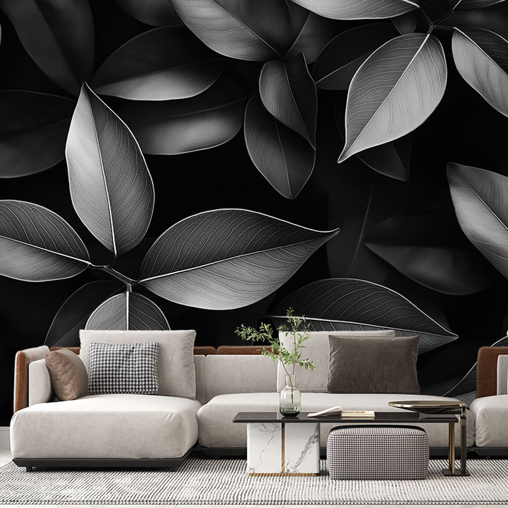 Black and white leaf pattern mural wallpaper creating drama in a modern living room with minimal furniture