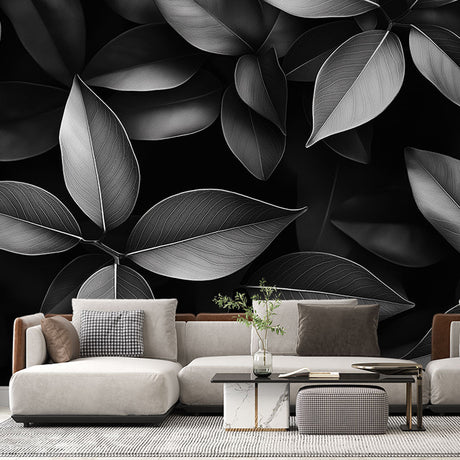 Black and white leaf pattern mural wallpaper creating drama in a modern living room with minimal furniture