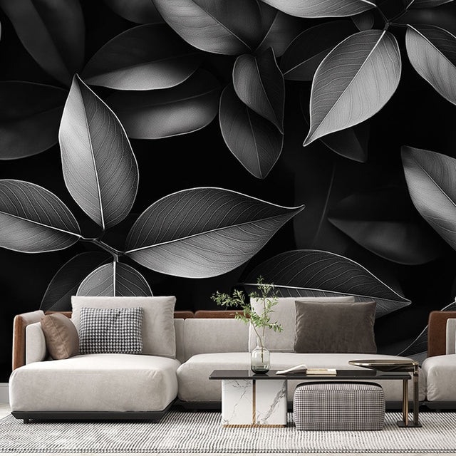 Black and white leaf pattern mural wallpaper creating drama in a modern living room with minimal furniture