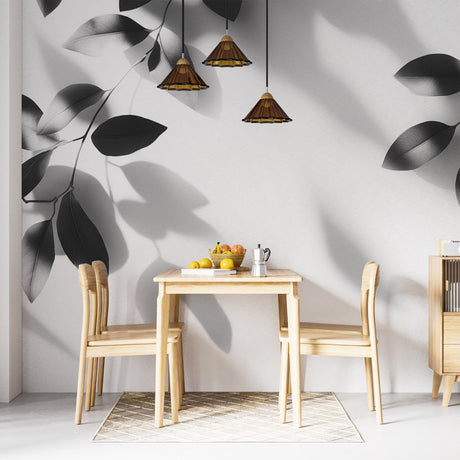 Black and white leaf wallpaper creating depth in a modern living room with natural light highlighting the shadow patterns