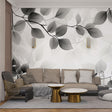 Black and white botanical wallpaper with translucent leaves creating a dramatic statement wall in a modern living room