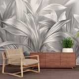 Silver leaf wallpaper mural in modern dining room with dramatic lighting showcasing metallic botanical design