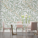 Sage green leaf pattern wallpaper in a serene bedroom setting with morning light