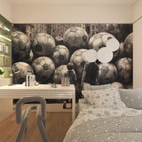 Football wall mural creating depth in a modern living room with monochrome soccer pattern