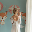 Forest Animals Wallpaper in cozy nursery with rocking chair and soft lighting, showing floating fox and pink balloons