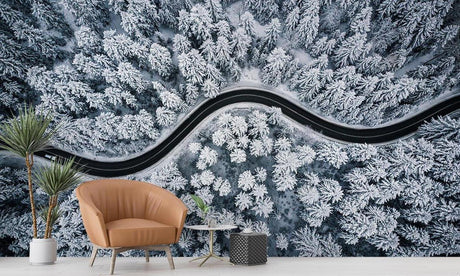 Aerial Snow Forest Road Mural displayed in a modern living room, showing white snowy trees and winding path from above