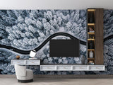 Winter forest wallpaper creating depth in a minimal bedroom, featuring aerial view of snow-covered pines