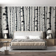 Black and white birch forest wallpaper creating a dramatic statement wall in a modern minimalist living room