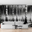 Black and white forest wallpaper creating depth in a modern living room with minimal furniture and natural light
