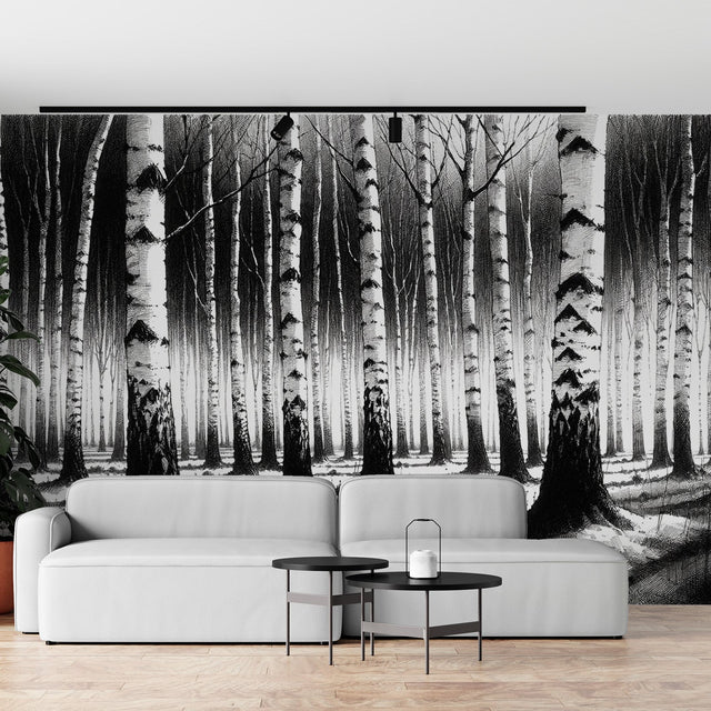 Black and white forest wallpaper creating depth in a modern living room with minimal furniture and natural light