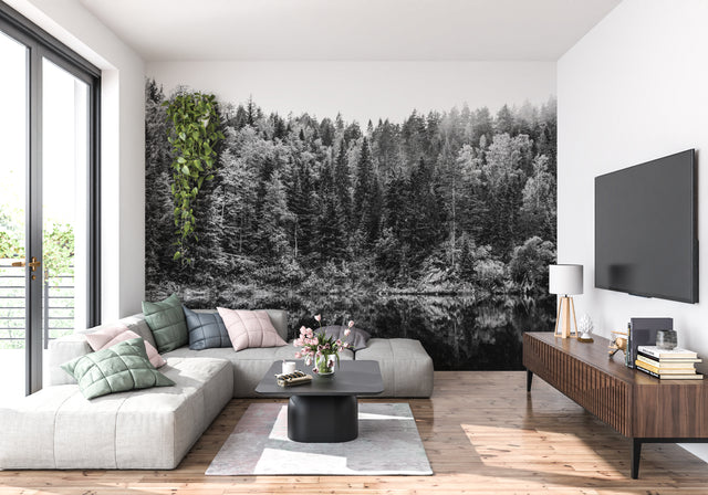 Black and white forest wallpaper creating depth in modern living room with minimal furniture