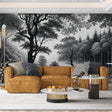 Black and white forest wallpaper mural creating depth in a modern living room with minimal furniture