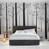 Black and white forest wallpaper creating depth in a modern Scandinavian living room with natural light