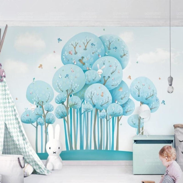 Blue forest wallpaper with butterflies creating a magical atmosphere in a modern nursery with white furniture