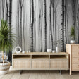 Black and white forest wallpaper creating a serene atmosphere in a modern living room with minimal furniture