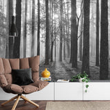 Black and white forest mural wallpaper creating depth in modern living room with minimal furniture