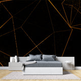 Geometric black and gold wallpaper in modern living room creating dramatic accent wall